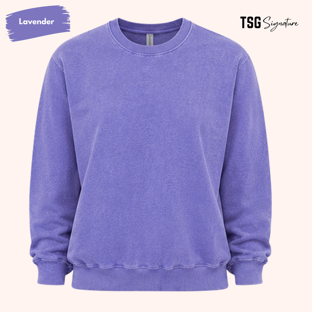 A lavender crewneck sweatshirt shown flat against a light cream background, with a purple paint-splatter label reading 'Lavender' in the top-left and 'TSG Signature' in the top-right.