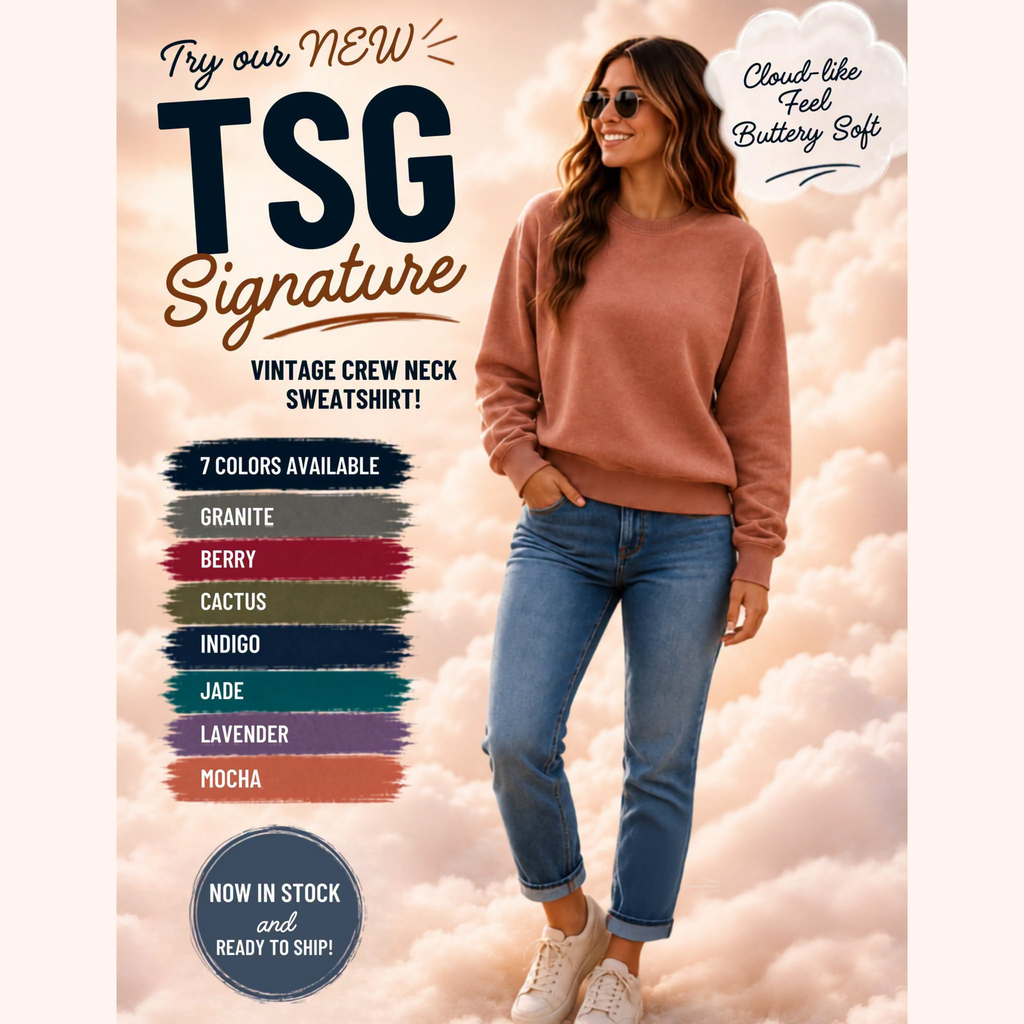 A woman wearing a dusty rose crewneck sweatshirt and blue jeans stands against a soft pink cloud background. The image includes promotional text for a TSG Signature sweatshirt, showing available colors in a vertical color swatch list and badges like 'Cloud-like Feel Battery Soft' and 'Now in stock and ready to ship!'.