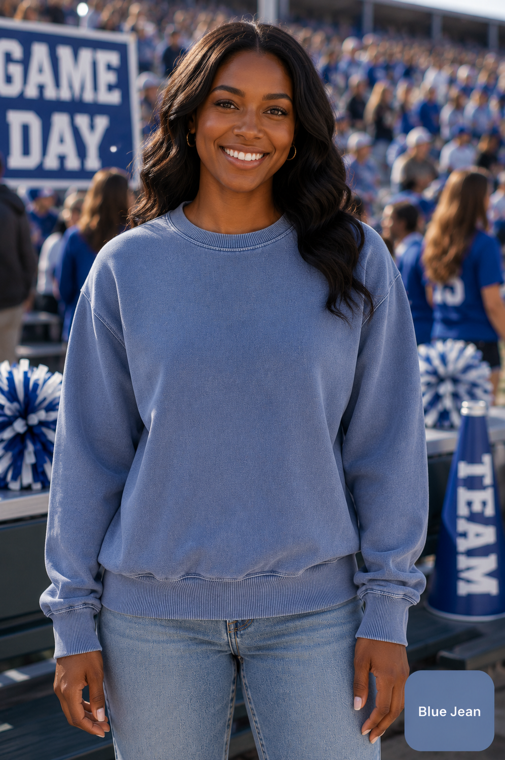 A woman wearing a light blue crewneck sweatshirt and light blue jeans stands in a stadium crowd, with a 'Blue Jean' color label overlay in the bottom right corner.