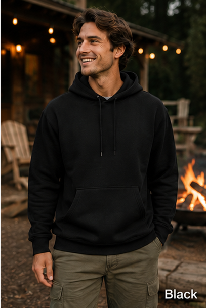 A man wearing a black pullover hoodie stands outdoors near a campfire at dusk, with a cabin and string lights blurred in the background. The word 'Black' appears in the bottom right corner.